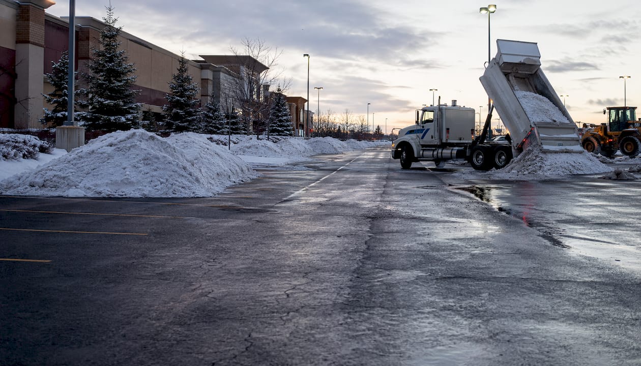 Overhead view of snow stacking and hauling at parking lot