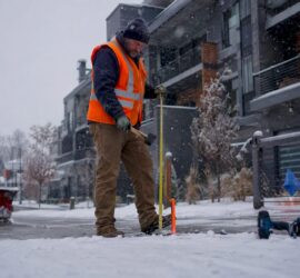 Property manager installing fiberglass driveway stakes