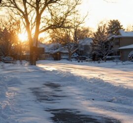 Snow plow clearing snow on residential driveway