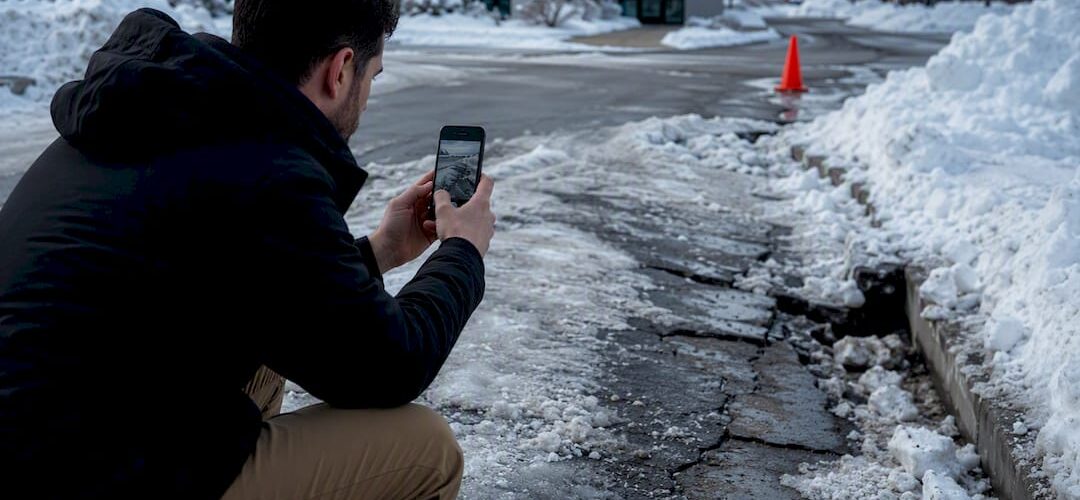 Manager documenting storm damage in commercial lot