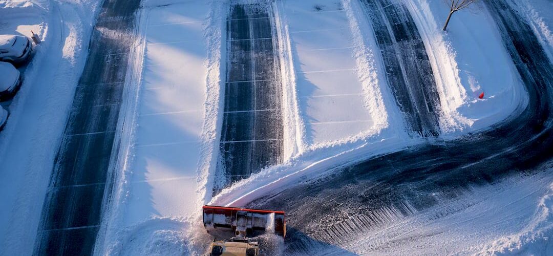 Snowplow creating organized parking lot lanes
