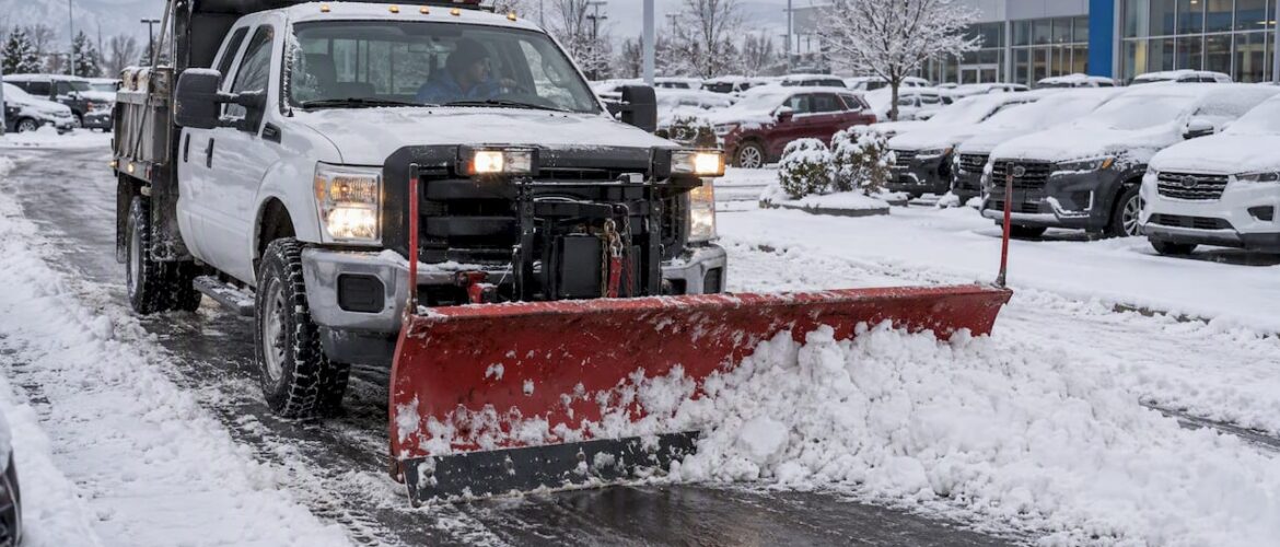 Snow plow clearing dealership access lane