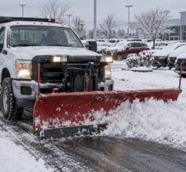 Snow plow clearing dealership access lane
